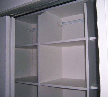 Top shelf of wardrobe specially cut to create easy access to storage space