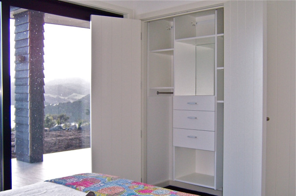 Wardrobe with built-in mirror and views of mountains outside Coromandel town